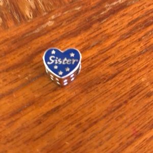 Charm for charm bracelet, silver and blue with word “Sister” in white.